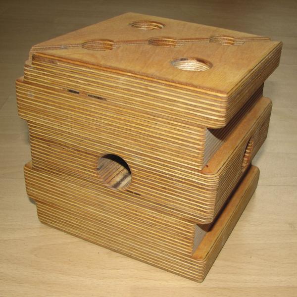 Holzblock mit mehreren Schichten und runden Aussparungen, stapelbar und robust.