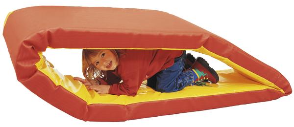 Kind spielt versteckt in zusammengeklapptem roten und gelbem Spielmattenwürfel.