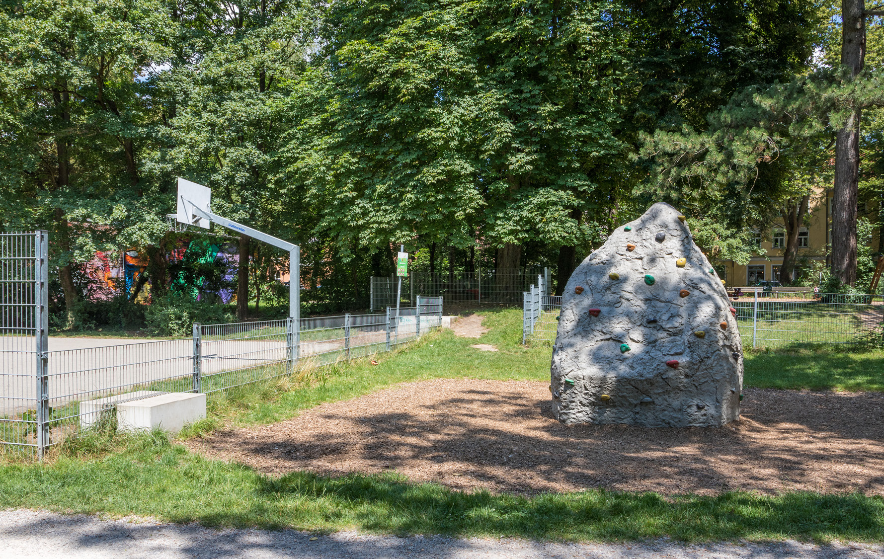 Basketballfreiplatz inklusive eines Kletterfelsen mit verschiedenen Klettergriffen.