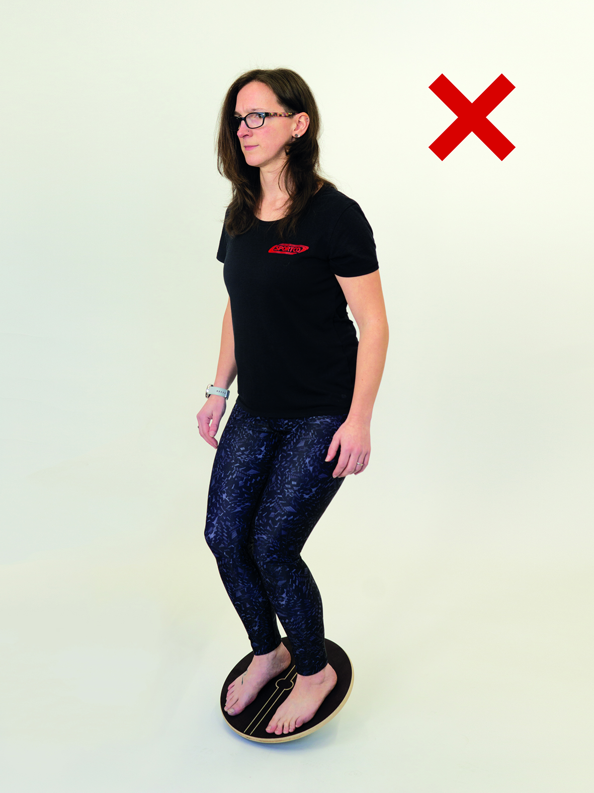 Frau steht mit beiden Beinen auf Therapiekreisel und hält Gleichgewicht in der Mitte
