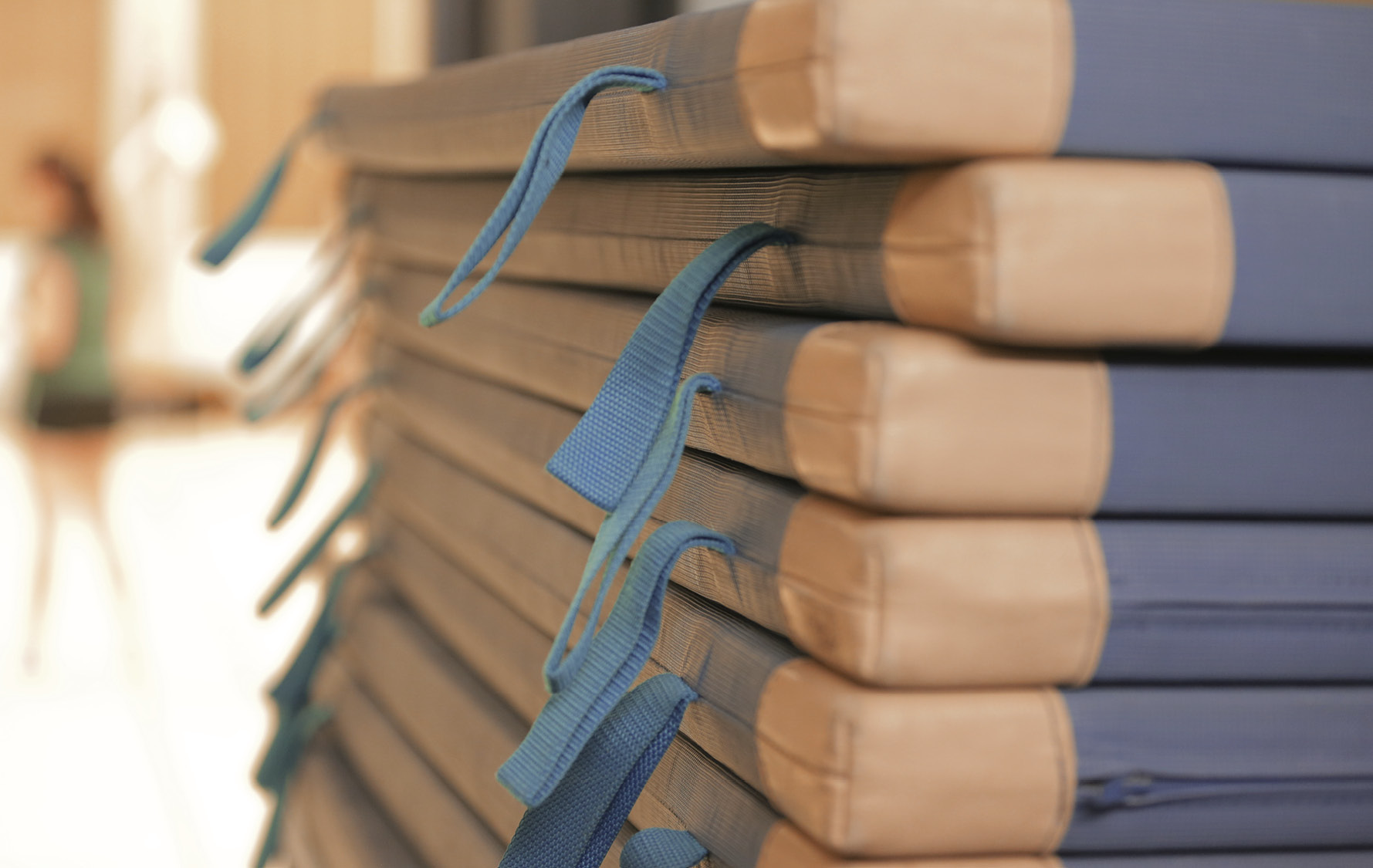 Gestapelte Turnmatten mit verschwommenem Hintergrund.