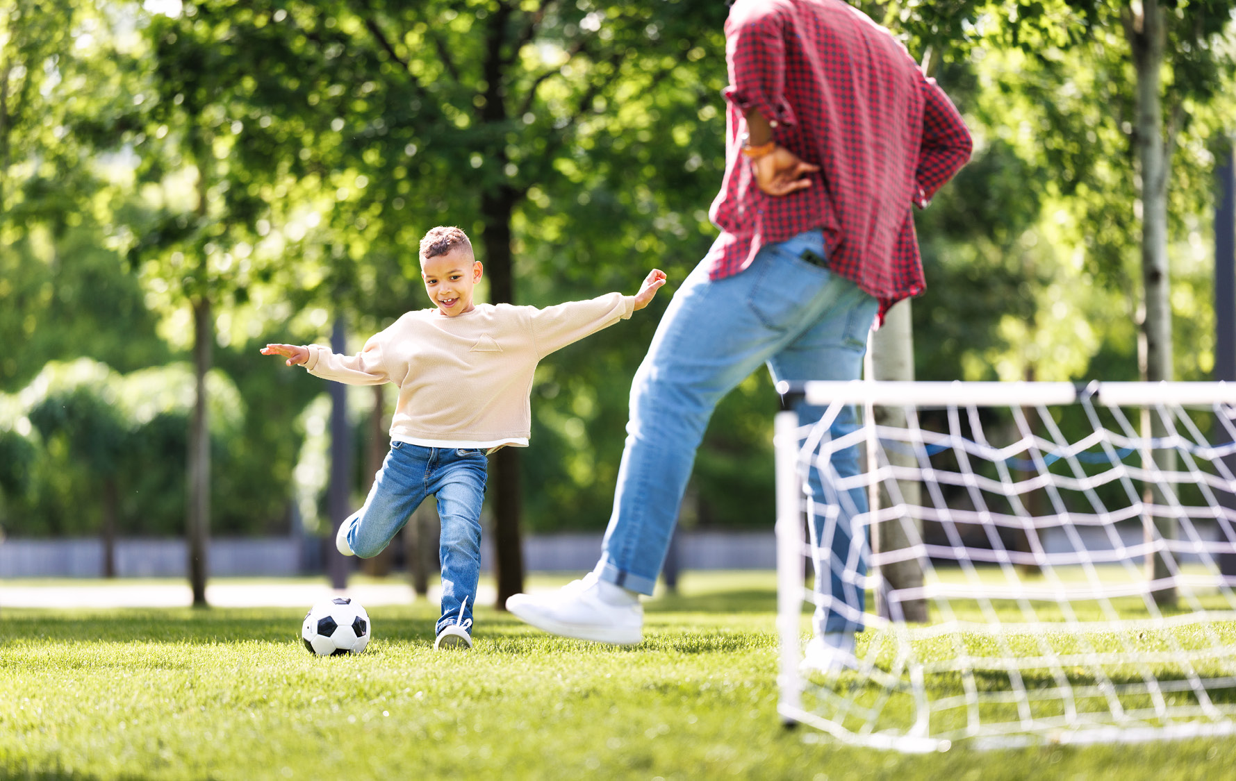 Kind spielt mit Vater Fußball